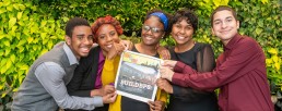 five students holding a newspaper from WriteBoston's TiP program