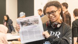 image of student holding the TiP newspaper