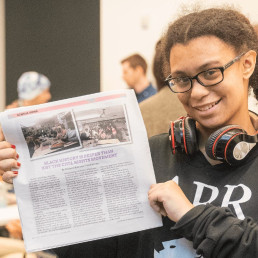 image of student holding the TiP newspaper