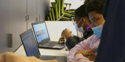 two students look at teens in print website on laptops