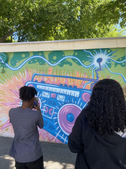 student photographs a mural during ALTAS