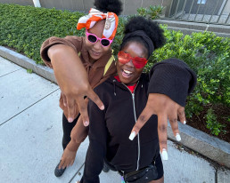 two students in sunglasses smiling at the camera